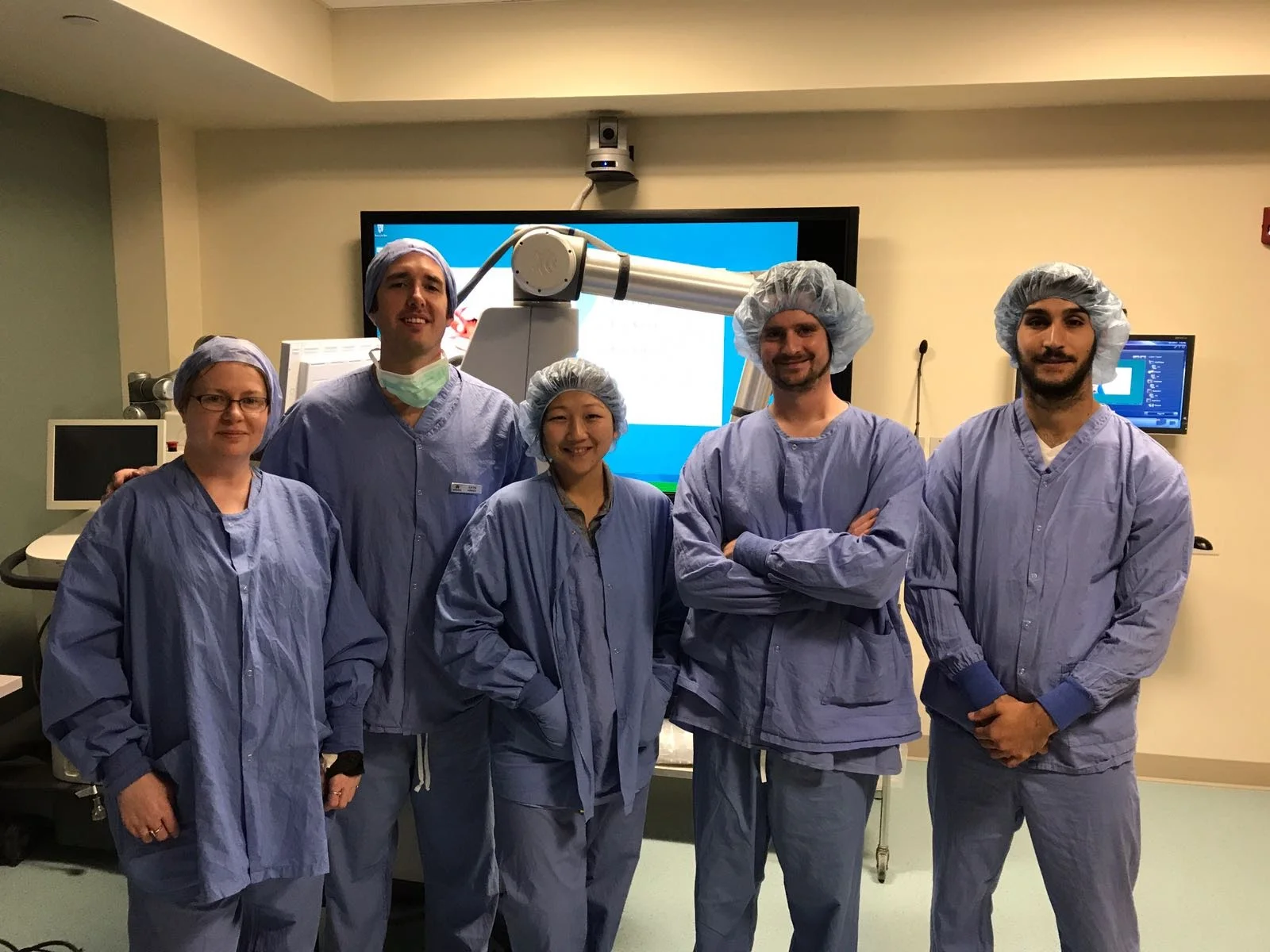 The design and research team in scrubs during FDA usability testing in front of the Modus X system